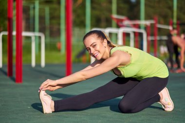 Çalıştırdıktan sonra germe. Genç güzel kadın egzersiz spor toprağa uzanan yapıyor spor giyim
