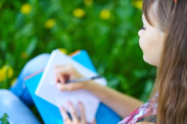 kız öğrenci park defterde yazılı. Kolej veya üniversite sınavları için hazırlık