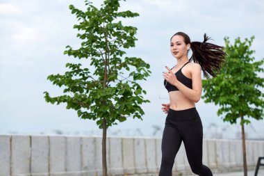 Gün batımında köprüde koşan güzel kadın.