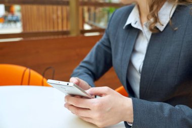 Kadın iş holding akıllı telefon ile arka plan bulanık.