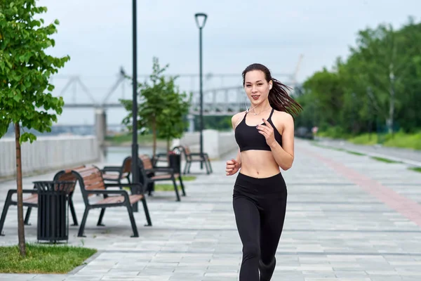 Gün batımında köprüde koşan güzel kadın.