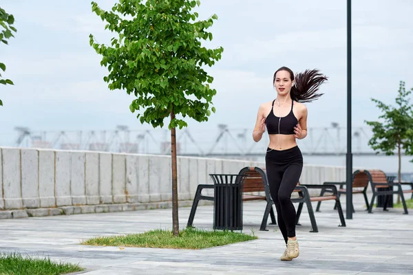 Gün batımında köprüde koşan güzel kadın.