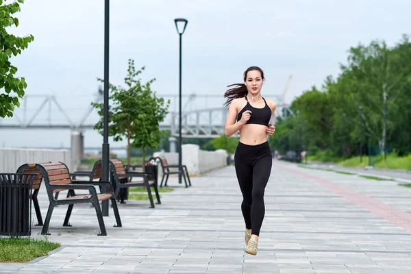 Gün batımında köprüde koşan güzel kadın.