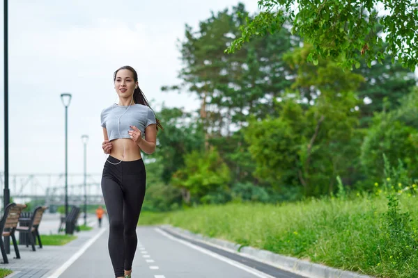 Gün batımında köprüde koşan güzel kadın.
