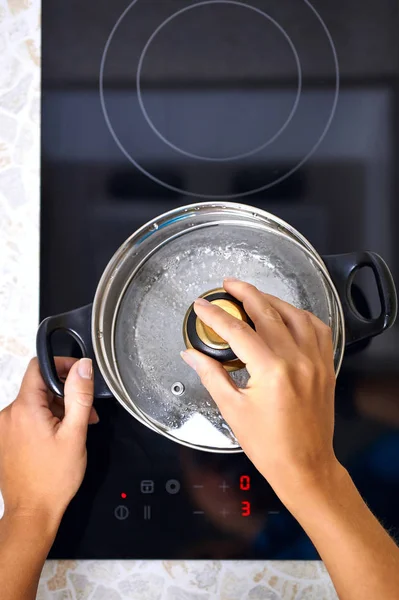Kobiety Ręcznie Otworzyć Rondlu Nowoczesną Kuchnię Kuchenką Indukcyjną — Zdjęcie stockowe