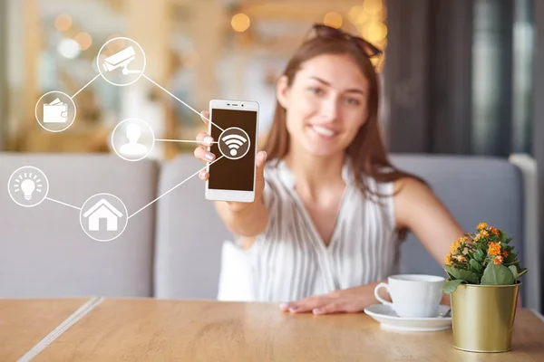Wi-Fi otomasyon uygulamalarına bağlı modern cep telefonu kullanan bir kadın. Evde uzaktan sanal denetim
