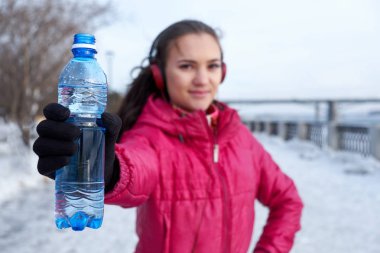 Drinking during sport. Young woman drinking water after run clipart