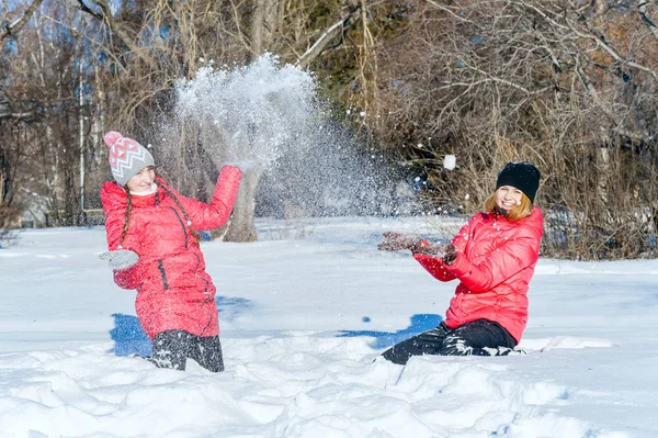 室外的肖像 两个年轻快乐的女孩抛出雪 纷纷拿起雪球 在冬季公园玩 — 图库照片