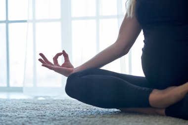 Yoga. Evde yoga meditasyonu yapan hamile bir kadın. Sağlık yaşam tarzı konsepti ve bebek bakımı.