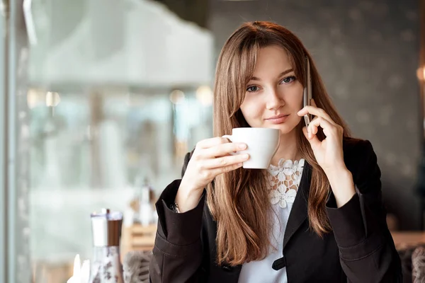 Fiatal üzleti nő beszél a telefonon, a kávézóban — Stock Fotó