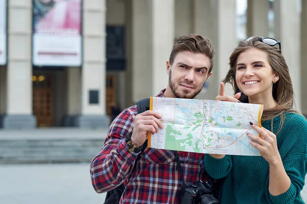 Casal jovem com um mapa na cidade. Turistas felizes cidade turística com mapa — Fotografia de Stock