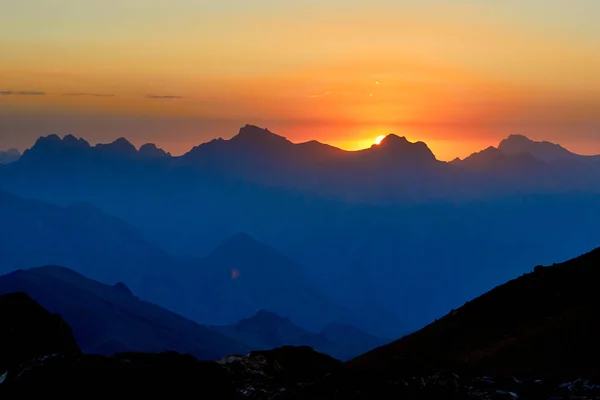 Mountain silhouettes at the sunset, orange and red colors in the sky, Fann, Pamir Alay, Tajikistan — Stock Photo, Image