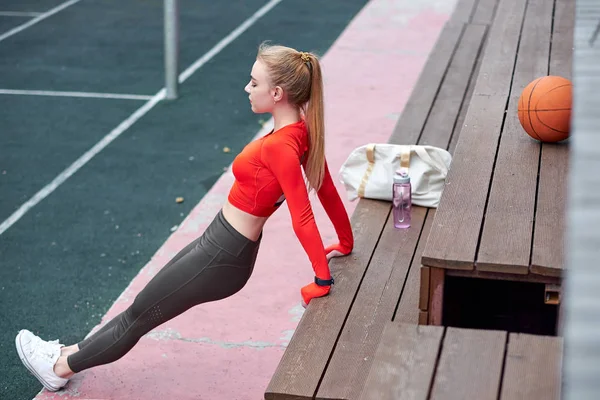 Sporcu kadın ilaç topuyla bacak esneme egzersizi yapıyor. Formda bir kadın spor salonunda topla egzersiz yapıyor.. — Stok fotoğraf
