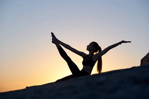 Siluet kadın yoga yapıyor ya da gün batımında ya da gün doğumunda geriniyor. — Stok fotoğraf