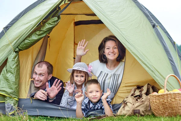 Genitori familiari e due bambini nella tenda del campo. Madre felice, padre, figlio e figlia in vacanza estiva — Foto Stock