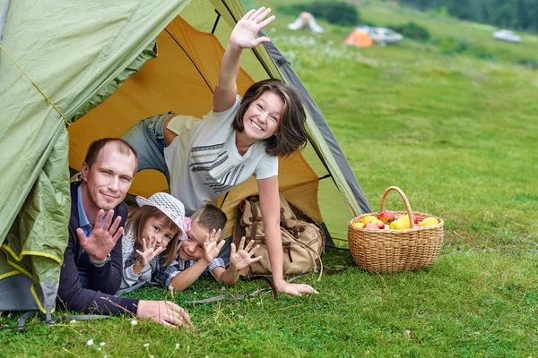 Genitori familiari e due bambini nella tenda del campo. Madre felice, padre, figlio e figlia in vacanza estiva — Foto Stock