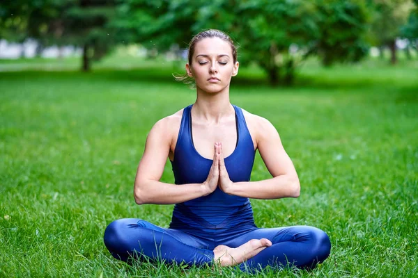 Yoga. Genç bir kadın parkta yoga meditasyonu yapıyor. Lotus pozu. Sağlık yaşam tarzı kavramı — Stok fotoğraf