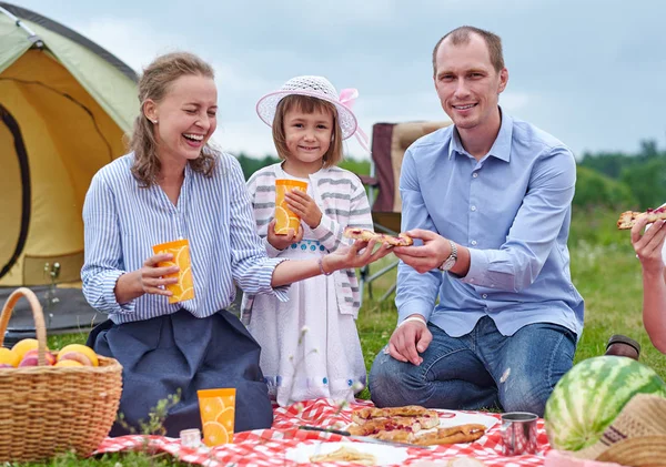 Famiglia felice che fa un picnic nel prato in una giornata di sole. Famiglia Godersi una vacanza in campeggio in campagna — Foto Stock