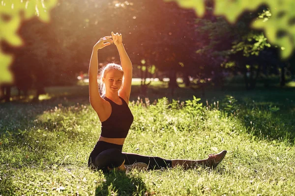 Yoga. Mujer joven practicando yoga o bailando o estirándose en la naturaleza en el parque. Concepto estilo de vida. — Foto de Stock