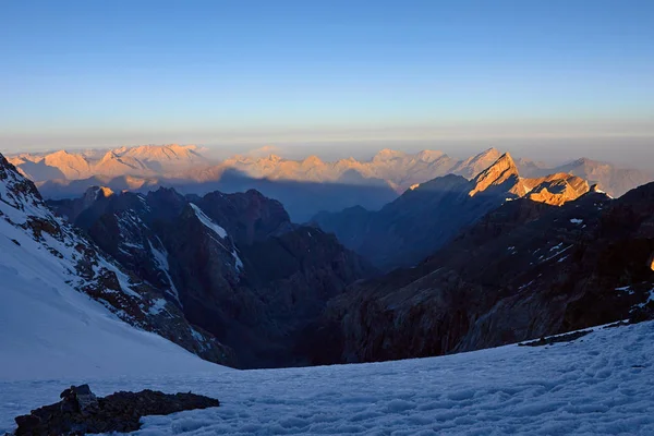Salida del sol en las montañas. Reflejo del sol rojo en los picos de nieve de montaña, pase Mirali, 5300, Fann, Pamir Alay, Tayikistán — Foto de Stock
