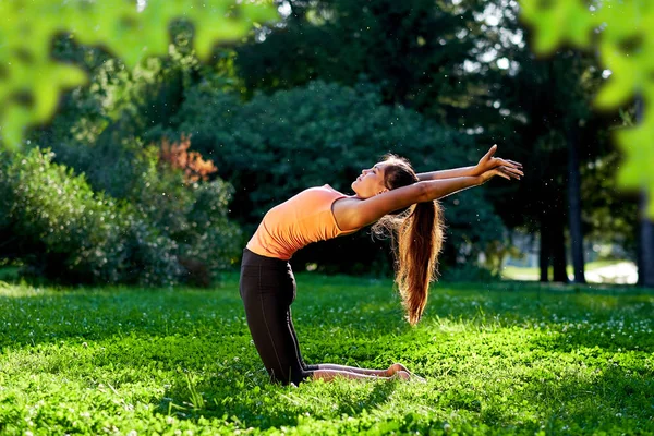 Yoga. Mujer joven practicando yoga o bailando o estirándose en na — Foto de Stock