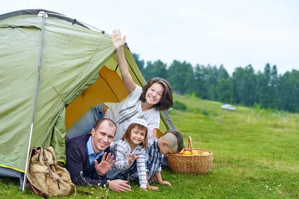 Genitori familiari e due bambini nella tenda del campo. Madre felice, padre, figlio e figlia in vacanza estiva — Foto Stock