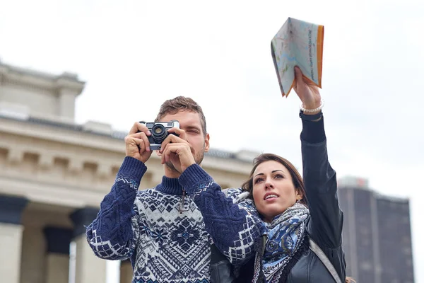 Gezintide ya da şehir turunda fotoğraf çeken mutlu bir çift turist. Bir harita ve retro kamerayla birlikte seyahat edin. — Stok fotoğraf