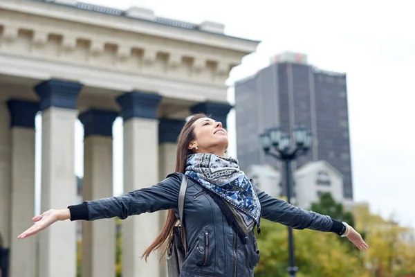 Donna felice in piedi con le braccia distese sullo sfondo dell'architettura della città urbana — Foto Stock