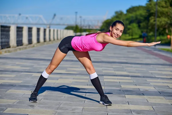 Mulher fitness fazendo exercícios de alongamento no fundo da cidade urbana — Fotografia de Stock
