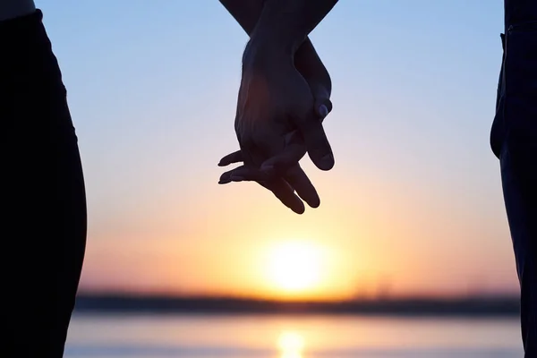 De mãos dadas na praia. Silhueta casal ao nascer do sol de mãos dadas em cena romântica . — Fotografia de Stock