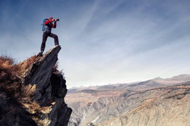 Yürüyüş blogcusu dağların manzarasının fotoğrafını çekiyor. Seyahat yaşam tarzını ve macera tatillerini paylaşmak. Açık hava modern teknolojisini kullan