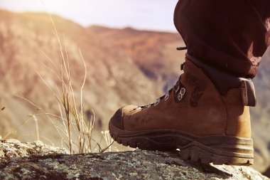 Genç kadın dağcı bacakları dağın tepesinde