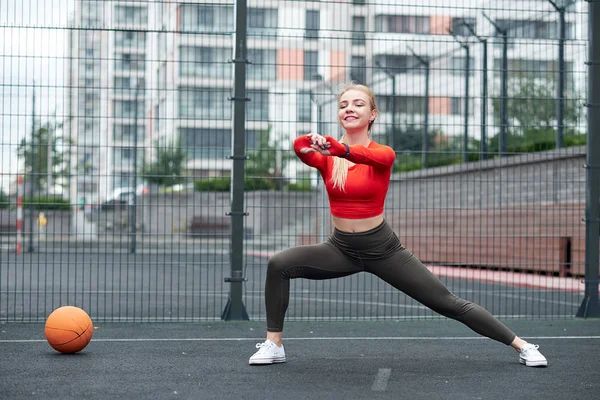 Deportiva haciendo ejercicio de estiramiento de piernas con balón de medicina. Fit mujer haciendo ejercicio con pelota en el entrenamiento de gimnasio. — Foto de Stock