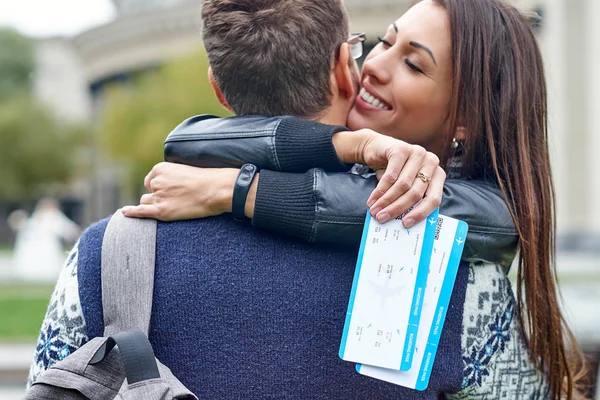 Felice allegra coppia che abbraccia e mostra biglietti aerei. uomo che fa una sorpresa a una donna - dando i biglietti per una luna di miele — Foto Stock
