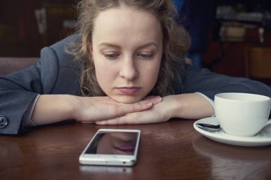 Telefon ve bekleyen mesaj veya arama arayan hayal kırıklığına üzgün kadın
