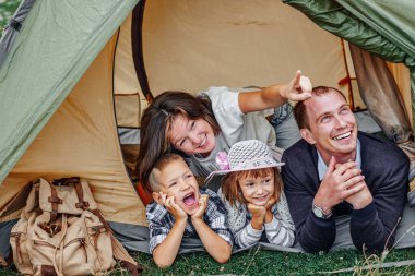 Aile ve iki çocuk kamp çadırında. Mutlu anne, baba, oğul ve kız yaz tatili.