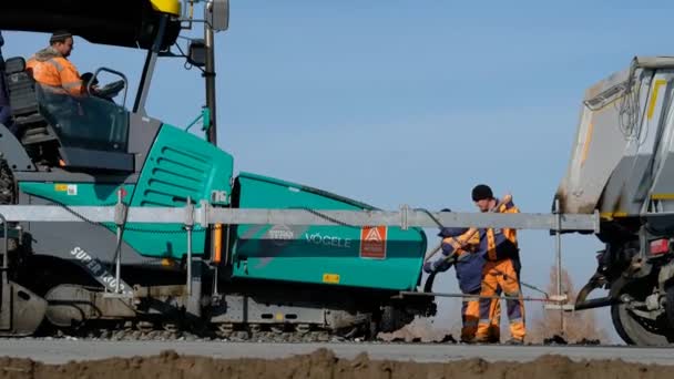 RUSIA, Novosibirsk - 30 de mayo de 2020: Obras de construcción de carreteras con máquina compactadora de rodillos y terminadora de asfalto — Vídeos de Stock