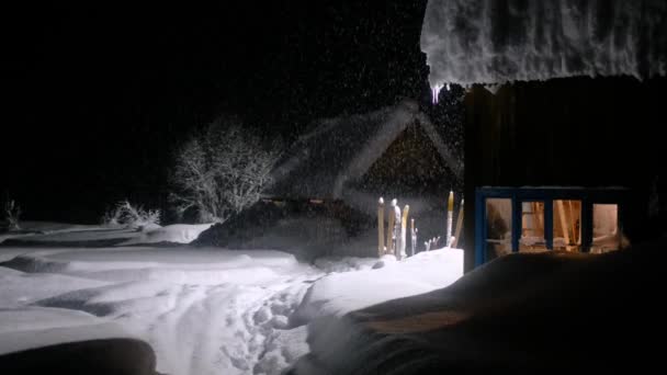 Berghaus und Fichte im Schnee in der Nacht im Wald. Es schneit — Stockvideo