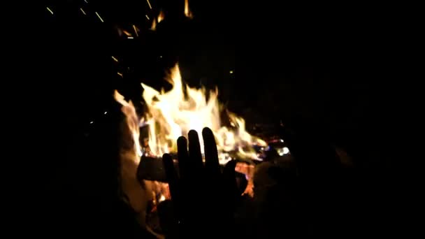 Manos de hombre calentándose junto al fuego del campamento. Partes del cuerpo del macho adulto en la naturaleza. — Vídeo de stock