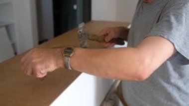 Marangoz detayları çekiç ve çivilerle işaretliyor.