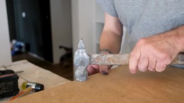 Marangoz detayları çekiç ve çivilerle işaretliyor.