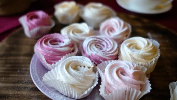 Připravené pusinky nebo marshmallows nebo cupcakes v cukrárně na dřevěném stole — Stock video