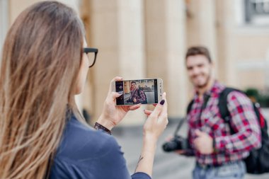 Birkaç turist fotoğraf çekiyor. Şehir turunda tatil fotoğrafı için poz veren adam.