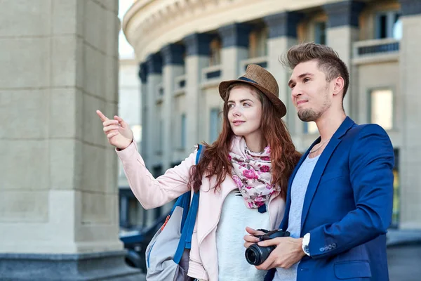 Gezintide ya da şehir turunda fotoğraf çeken mutlu bir çift turist. Şehir mimarisinin arka planında fotoğraflar — Stok fotoğraf