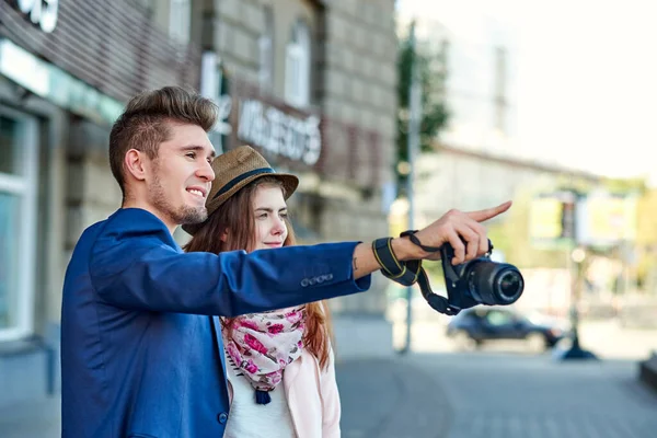 Amor feliz casal de turistas levando apontando para um marco ou showplace na cidade — Fotografia de Stock