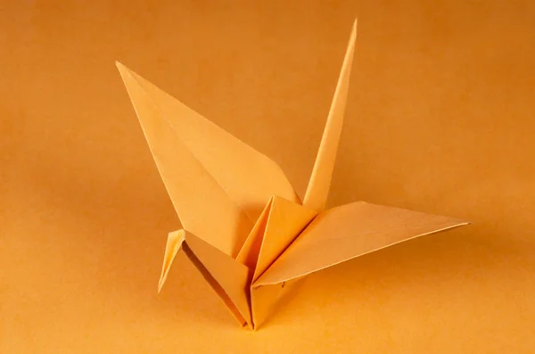 Tsuru grúa de origami naranja sobre fondo naranja — Foto de Stock