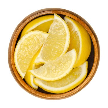 Limonun yarısı ahşap kasede. Taze kesilmiş sarı yenilebilir narenciye meyvesi. Deniz aygırı limonu. Limon suyu yemek pişirmek ve temizlik için kullanılır. Yakından, yukarıdan, beyaz, izole edilmiş yemek fotoğrafı..