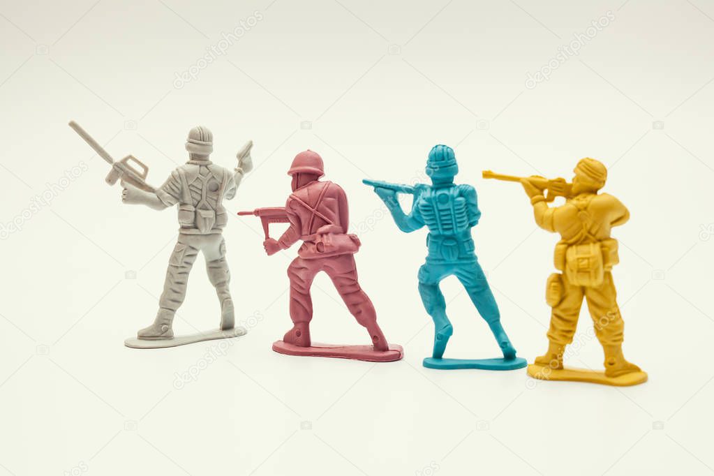 macro plastic toy soldiers targeting guns on hostage on white background