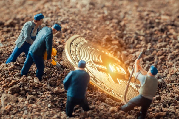 大きな光沢のあるビットコインを明らかにするために地面を掘るマクロ鉱夫フィギュア — ストック写真