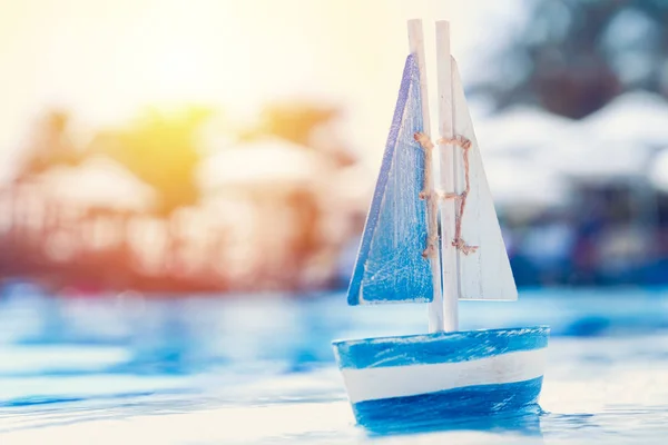 Wooden toy sailboat by the swimming pool in summertime — Stock Photo, Image